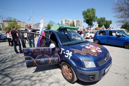 Автомобиль расписанный рисунками в память о Великой Победе в Отечественной Войне. На крыше автомобиля установлена башня танка.