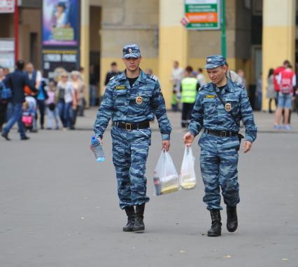 Покупки. На снимке: сотрудники правохранительных органов несут пакеты с продуктами питания.