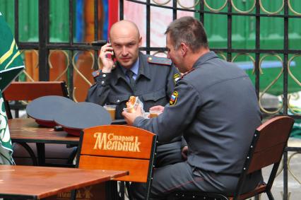 Прием пищи. На снимке: сотрудники правохранительных органов за столиком уличного кафе.