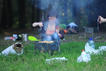 Природно-исторический парк \'Кузьминки-Люблино\'.  На снимке: девушка у мангала с шашлыком.