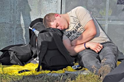 Аэродром `Тушино`. 15-й международный музыкальный фестиваль `Maxidrom`. Мужчина спит на рюкзаках.