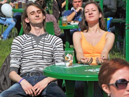 Аэродром `Тушино`. 15-й международный музыкальный фестиваль `Maxidrom`. Мужчина и женщина загорают за столом.
