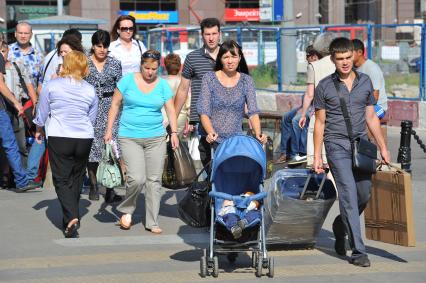 Семья с багажом на городской улице.