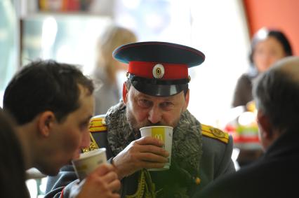 Мужчина в образе царя Николая II пьет кофе в Макдоналдсе.