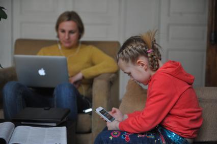 Женщина с ноутбуком и девочка с телефоном.