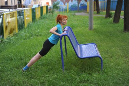 Девушка занимается фитнесом на природе.