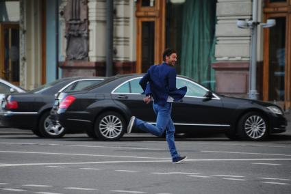 Мужчина перебегает проезжую часть дороги в неположенном месте.