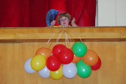 В тульской филармонии женщина сидит со связкой воздушных шаров.