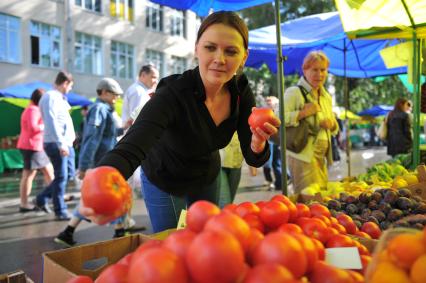 Ярмарка выходного дня. На снимке: женщина покупает продукты.