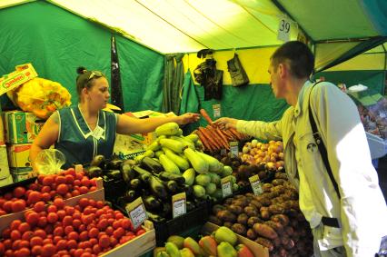 Ярмарка выходного дня. На снимке: мужчина покупает продукты.