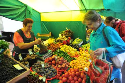 Ярмарка выходного дня. На снимке: женщина покупает продукты.