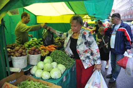 Ярмарка выходного дня. На снимке: женщина покупает продукты.