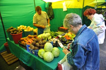 Ярмарка выходного дня. На снимке: женщина покупает продукты.