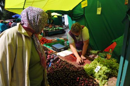 Ярмарка выходного дня. На снимке: покупательница смотрит товар