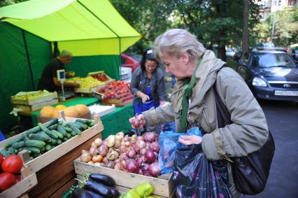 Ярмарка выходного дня. На снимке: женщина покупает продукты.