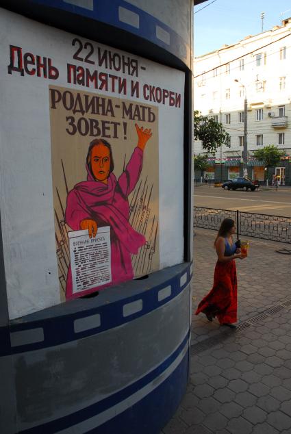 Копия плаката `Родина-мать зовёт`, в качестве афиши, рядом проходит девушка, ест чипсы.