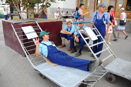 Грузчики с тележкой на Киевском вокзале. На снимке: мужчина сидит на тележке.