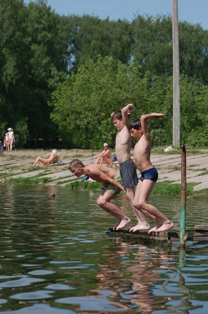 Дети купаются в водоеме, прыгают в воду.