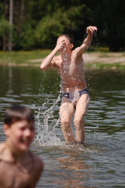 Дети купаются в водоеме, прыгают в воду.