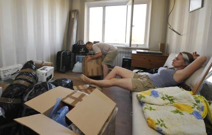 Переезд в новую квартиру. На снимке: мужчина перетаскивает коробку.