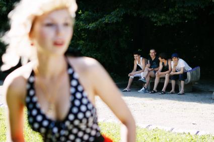 В Ставрополе прошла массовая фотосессия в стиле `PIN-UP`. На снимке: молодые люди на скамейке наблюдают за девушками.