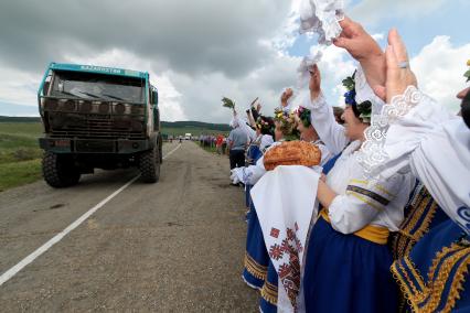 Казачий вокальный ансамбль поздравляет финишировавших участников, встречая хлебом-солью. На снимке: финиширование команды `Астана` под номером 308, пилот - Артур Ардавичус.