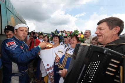 Казачий вокальный ансамбль поздравляет финишировавших участников. На снимке: пилот команды `Астана`, номер 308 Артур Ардавичус пробует хлеб-соль.