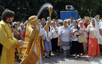 Служба во время празднования дня Петра и Февронии в Ставрополе. На снимке: священник с кропилом освящает прихожан.