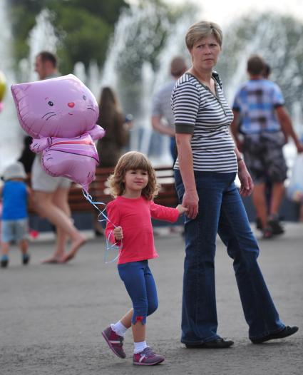 Женщина и девочка на городской улице.