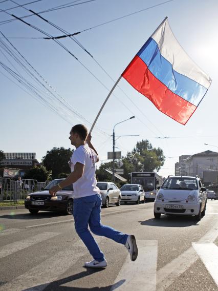 Волонтеры поздравляют автомобилистов с днем флага. На снимке: мужчина с российским флагом в руках.