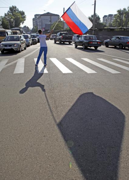 Волонтеры поздравляют автомобилистов с днем флага. На снимке: мужчина с российским флагом в руках.