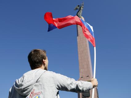 Волонтеры поздравляют автомобилистов с днем флага. На снимке: мужчина с российским флагом в руках.