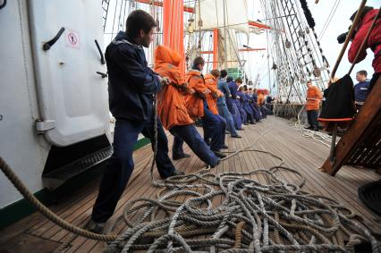 Барк `Седов` во время первого кругосветного путешествия. На снимке:  матросы поднимают паруса и укладывают канаты.