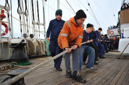 Барк `Седов` во время первого кругосветного путешествия. На снимке:  матросы поднимают паруса и укладывают канаты.