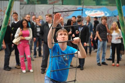 Представление на Старом Арбате. На снимке: мужчина забирается по подвесной лестнице.