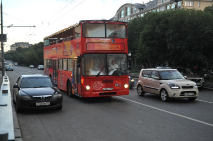 Двухэтажный автобус возит туристов по центру Москвы.