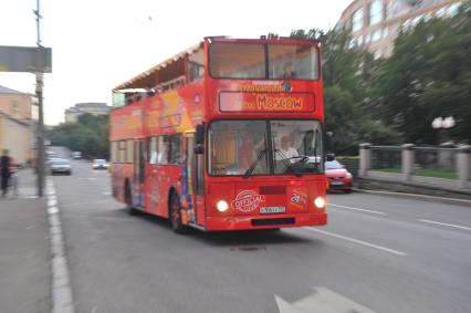 Двухэтажный автобус возит туристов по центру Москвы.