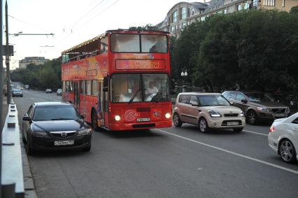 Двухэтажный автобус возит туристов по центру Москвы.