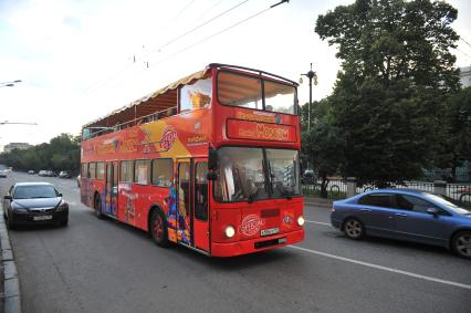 Двухэтажный автобус возит туристов по центру Москвы.