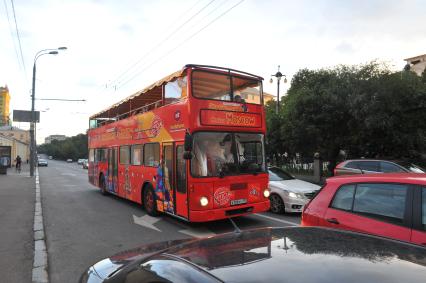 Двухэтажный автобус возит туристов по центру Москвы.