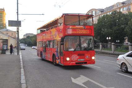 Двухэтажный автобус возит туристов по центру Москвы.