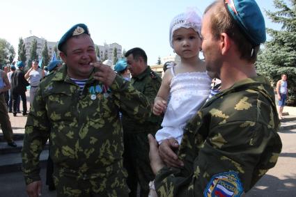 Празднование дня ВДВ в Казани. На снимке: Десантник общается с ребенком.