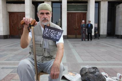 Митинг мусульман против произвола полиции. Площадь театра Камала. Казань. На снимке: Старик с палкой сидит, держит флажок с лозунгами.