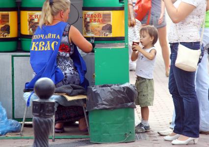 Продажа кваса на улице. Ребенок в ожидании напитка.