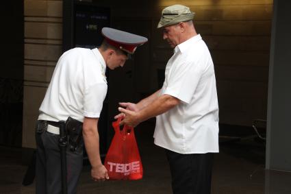 Полицейские в метро проводят операцию `Антитеррор`. На снимке: Мужчина показывает полицейскому содержимое пакета.