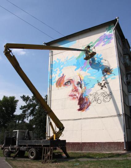 Международный фестиваль граффити в Казани посетили художники из Испании, Германии и Польши. На снимке: художник на подъемнике оформляет стену многоквартирного дома.