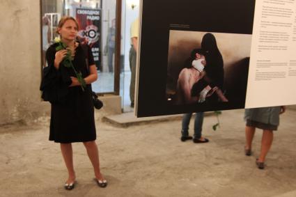 Фотовыставка `World press photo 2012`. На снимке: Девушка с цветком белой розы осматривает экспозицию выставки.