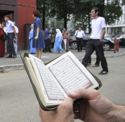 Священное писание в руках мусульманина.