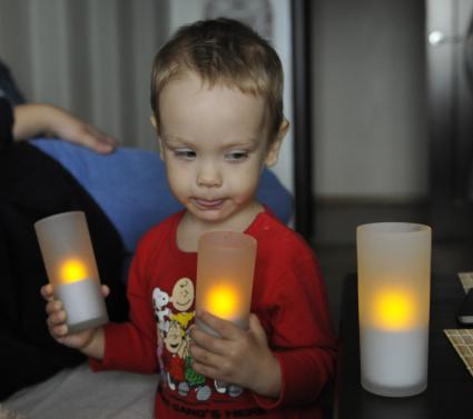 Ребенок со светодиодным светильником в форме свечки.