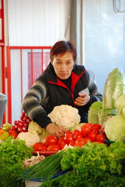 Продавец в овощном отделе на рынке.
